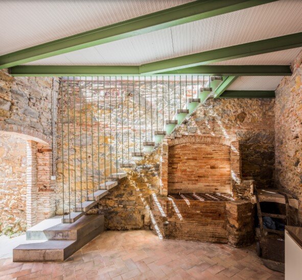 Каменная и кирпичная кладки эффектно гармонируют с современной лестницей в стиле лофт и бледно-салатовыми акцентами