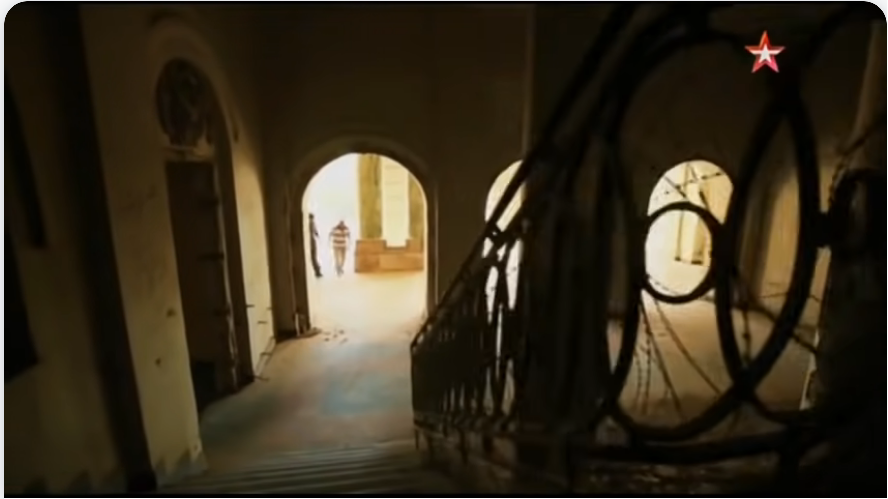 Вид с лестницы на холл и коридор вдоль дворца, Я.Семенов и А.Мерзликин поднимаются по небольшой лесенке в него из прихожей. Кадр из фильма 1979. Афганский «Шторм» - Военная приемка. След в истории / Штурм дворца Амина / 2016.