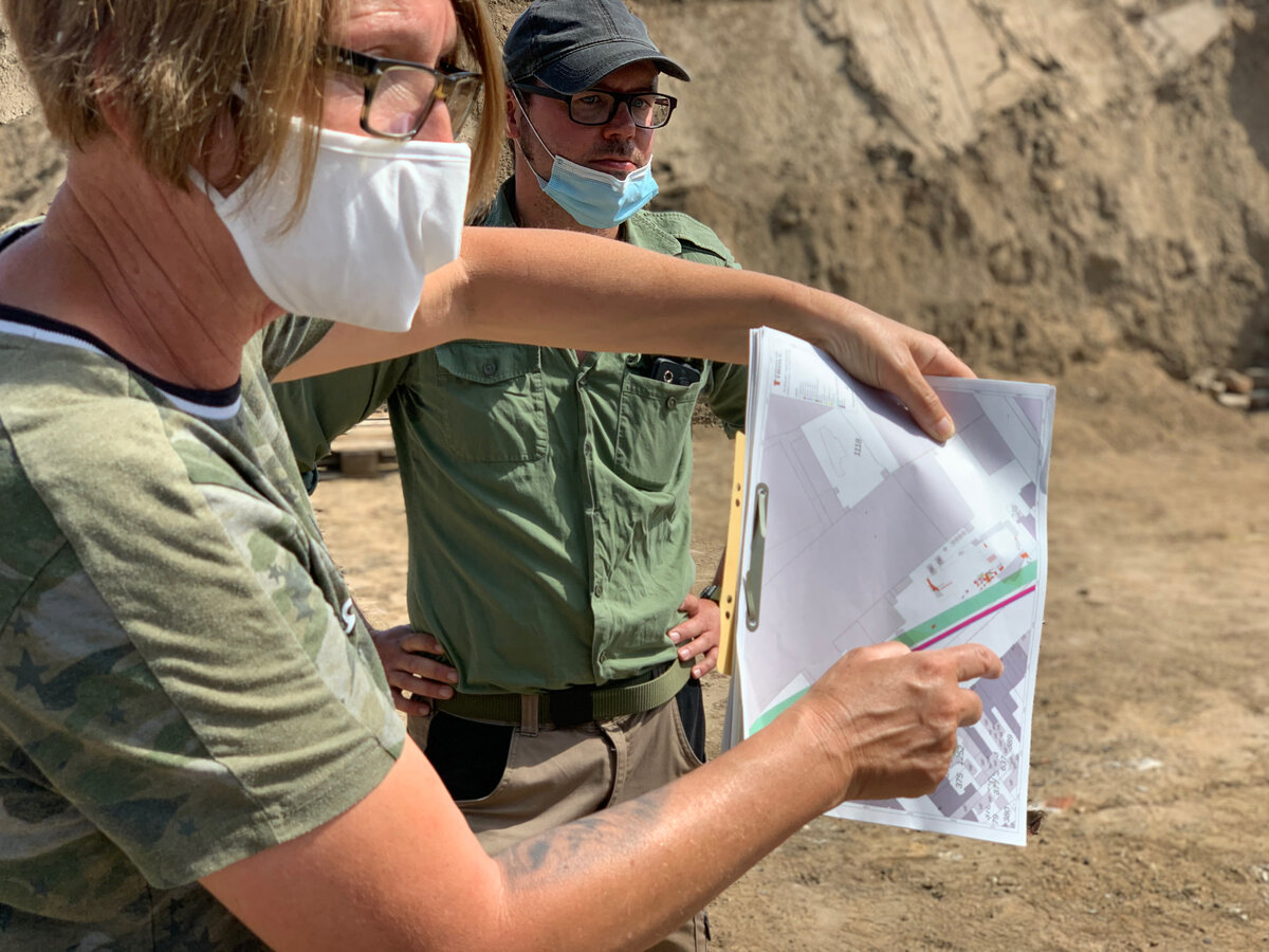 Археологи показывают на карте место находки.