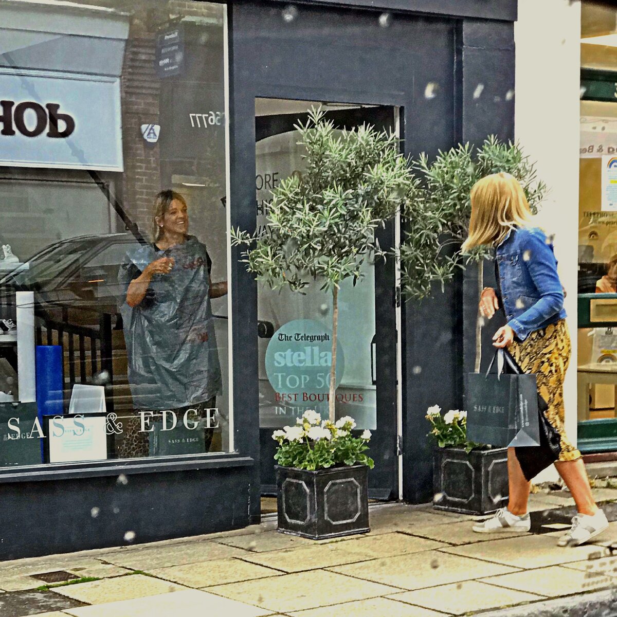 Продавец бутика, облачённая в мусорный мешок, прощается с покупательницей