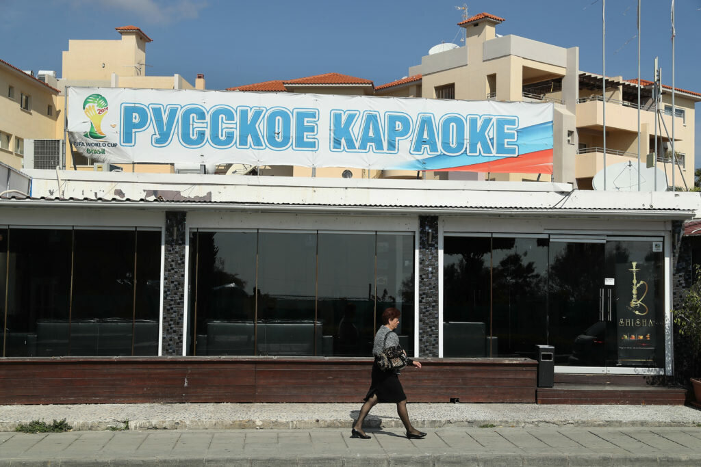 Женщина проходит мимо русского караоке-бара в Лимассоле | Шон Гэллап / Getty Images