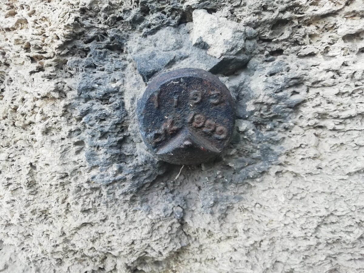 Нивелирная марка в фундаменте дома на пересечении улицы Малюгиной и переулка Островского