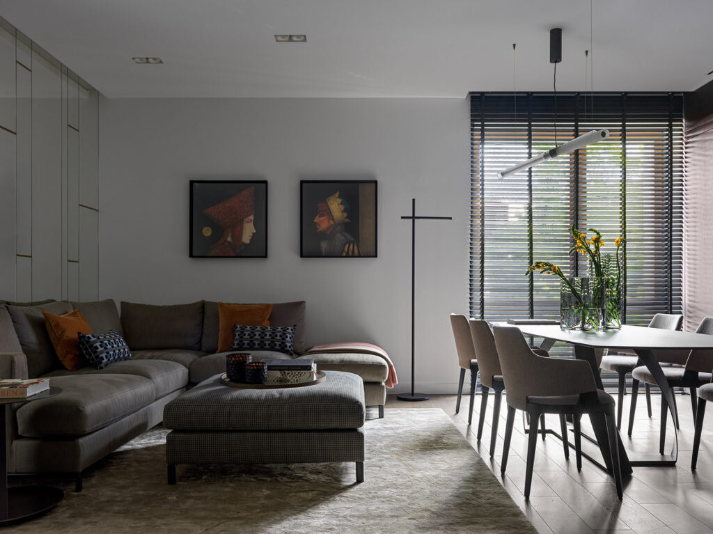 Фрагмент гостиной. Диван Loft, Giulio Marelli; подушки из ткани Hermès; на стене литографии итальянского художника Gino Donvito; около дивана круглый кофейный столик Richer, Minotti; торшер Twing, De Padova; стол и стулья, Potocco; над столом люстра, Baxter; вазы на столе, Menu (Galerie46). Зеркальное панно с металлическими вставками изготовлено по эскизам архитекторов.