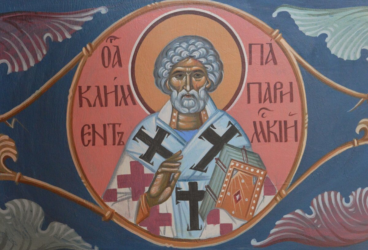 Роспись "святой Климент папа Римский". Храм Успения Пресвятой Богородицы "за верхом" г. Калуга. В иконографии святой Климент Римский, порой чрезвычайно напоминая апостола Петра, уже с ранних времен изображался с короткой вьющейся бородой и шапкой коротких курчавых волос, иногда с тонзурой (выбритый на макушке круг). Облачение имеет архиерейское. В древней Церкви принадлежавшие епископам фелони сплошь были покрыты изображениями крестов и назывались полиставриями (греч. многокрестие).