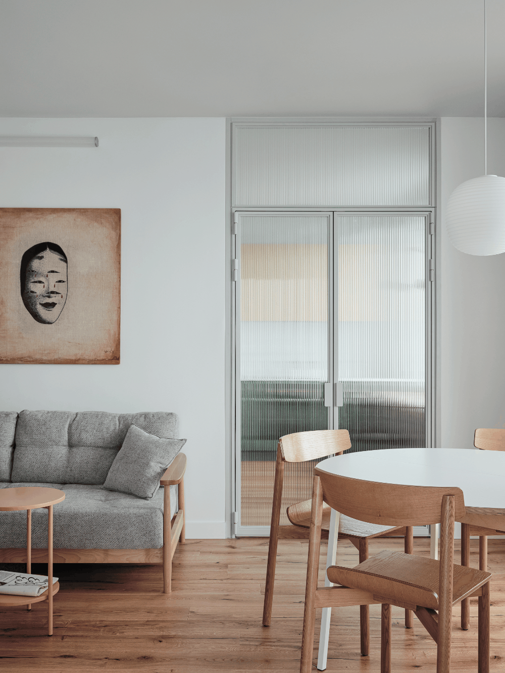  Фрагмент гостиной. Кухню отделяет от гостиной двустворчатая стеклянная дверь. Стулья, Artu; стол сделан на заказ; журнальный столик, Delo Design; диван, Y&S Design; люстра, New Works; на стене работа Владислава Бахвалова из коллекции заказчицы.