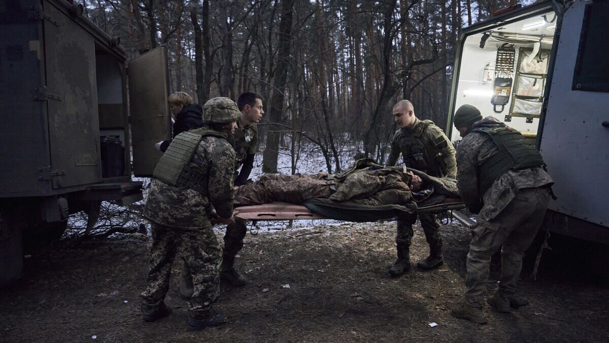    Медики помогают тяжело раненому украинскому солдату© AP Photo / LIBKOS