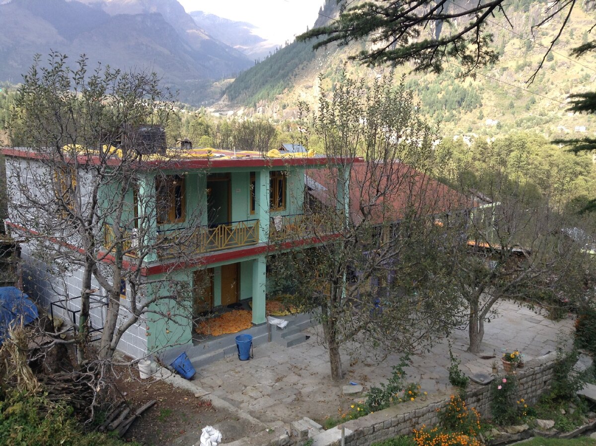 Дом индийской семьи в деревне на севере Индии. На плоской крыше дома удобно высушивать красные перцы чили. Порошок из них идет на продажу.