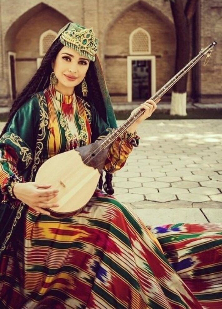 Узбекская девушка в национальной одежде с дутаром  в руки