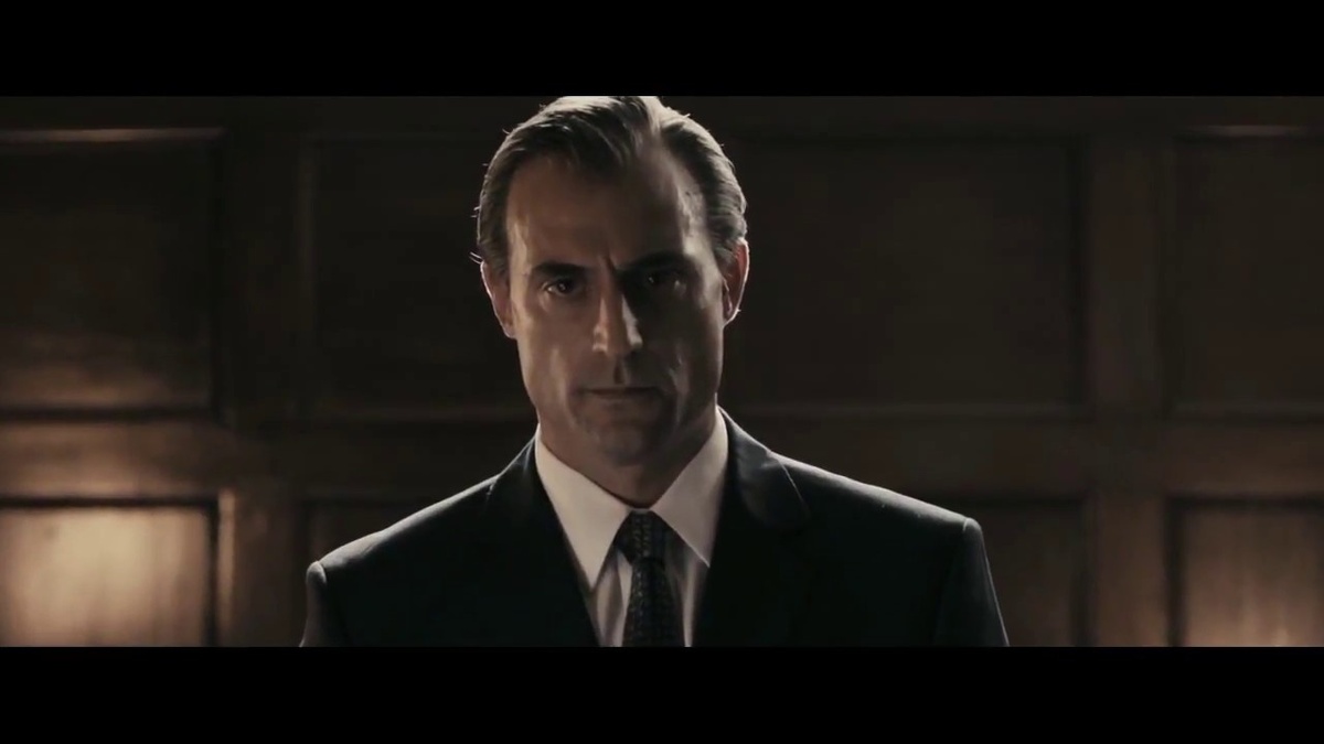 Марк Стронг в роли Арчи, помощника Ленни в Рок-н-ролльщике, опасный засранец в дорогом костюме, ах