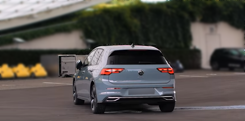 Задняя часть кузова издалека с включенными задними фонарями.