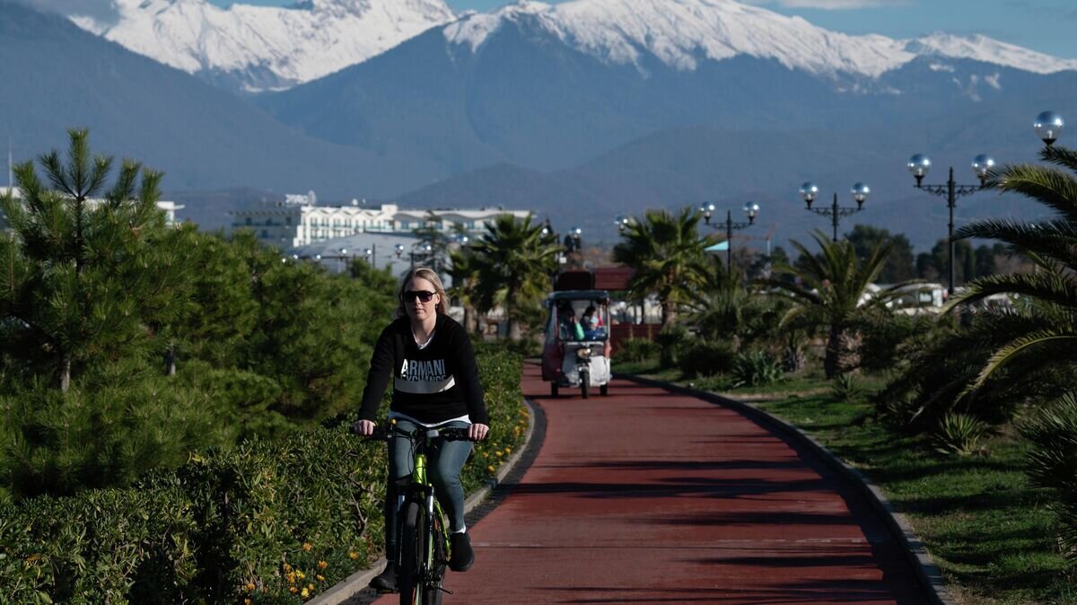    Девушка катается на велосипеде на набережной в поселке городского типа Сириус в Краснодарском крае© РИА Новости / Артур Лебедев