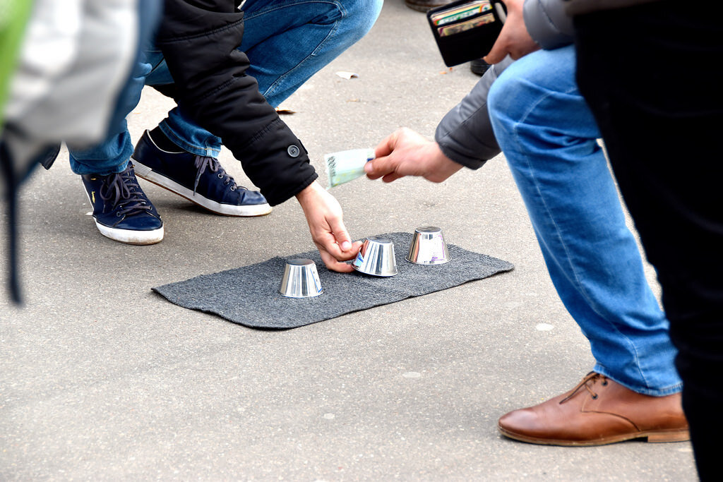 Фото из открытого источника. Игра в напёрстки на улице, про которую шла речь выше. 