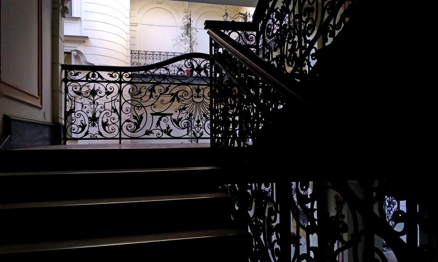 

Не  буду врать, это не обычный дом. На дверях его красуется  одиннадцатизубцовая корона – герб графского семейства Каройи,  известного, по крайней мере, с XIV века.

Время  строительства дома – то, которое в наших профессиональных кругах  называется «тогда же». В 1896 году Венгрия праздновала Тысячелетие  обретения Родины, и в городе по такому случаю было построено  невообразимое количество великолепных зданий. Это датируется 1897-м  годом. 
Попасть во  двор такого дома – удача редкая. Любопытствующих гостей не  ждут,  посторонних не пускают. И если в домах на Большом бульваре не редкость  парикмахерская или обменник, и потому зайти во двор можно на законных  основаниях, то тут – извините.
