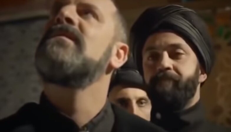 Рустем-паша узнал от Атмаджи о существовании тайной комнаты Хюррем и пытается разглядеть слуховое окошко под потолком зала заседаний. 