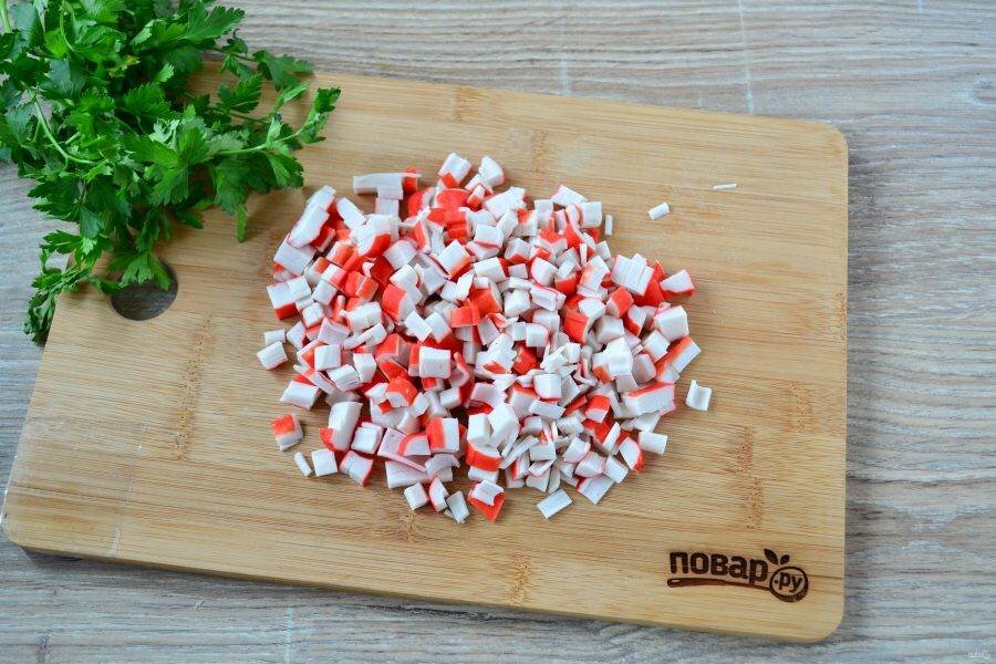 Крабовые палочки нарежьте мелким кубиком