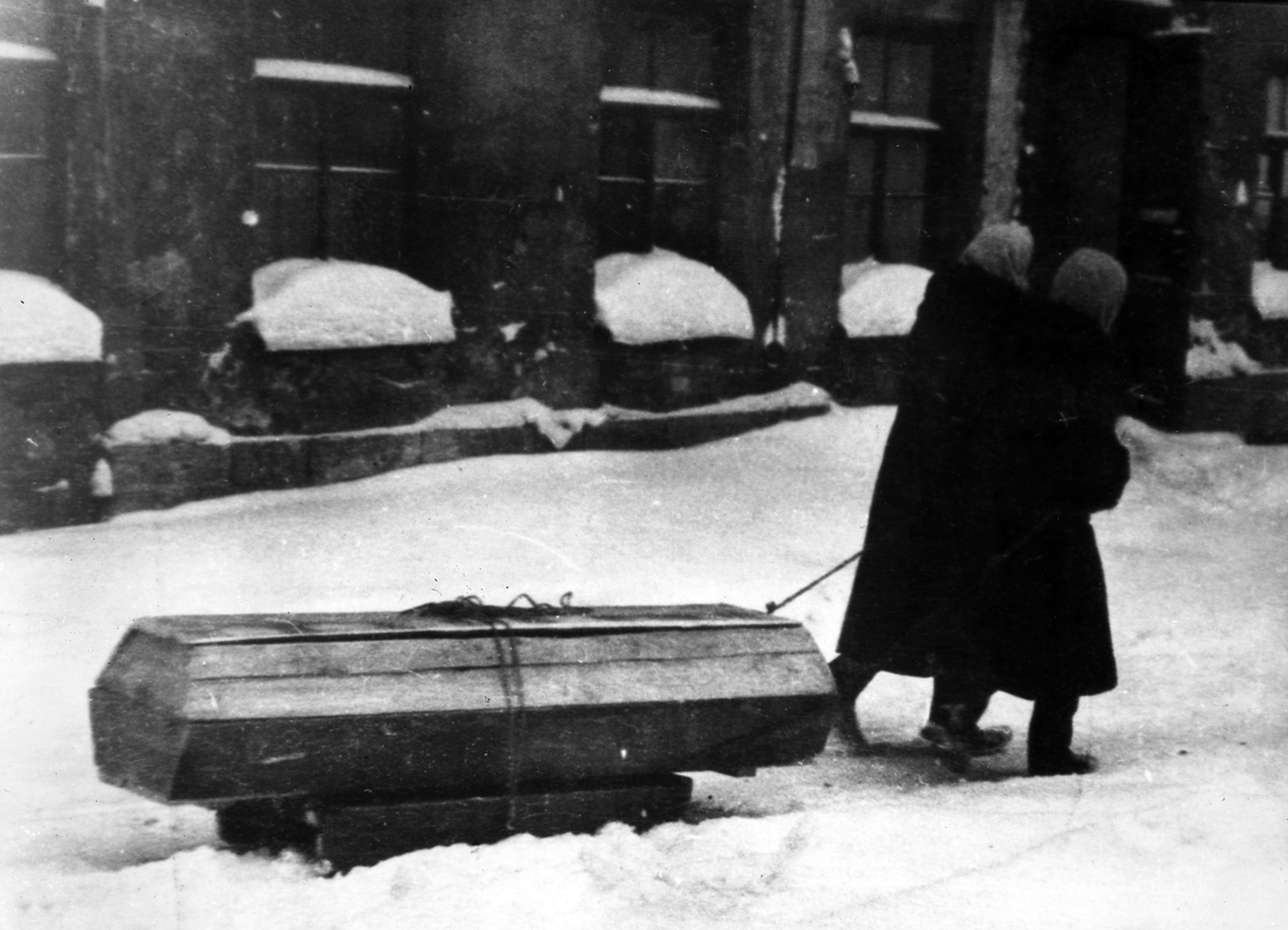 Жители блокадного Ленинграда везут на санках гроб с умершим. Зима 1941/1942 гг., Ленинград.