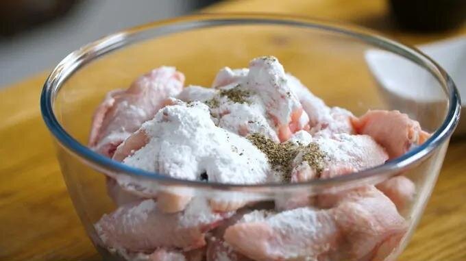 Тщательно сушим и соединяем куриные крылышки с разрыхлителем, солью и перцем. 