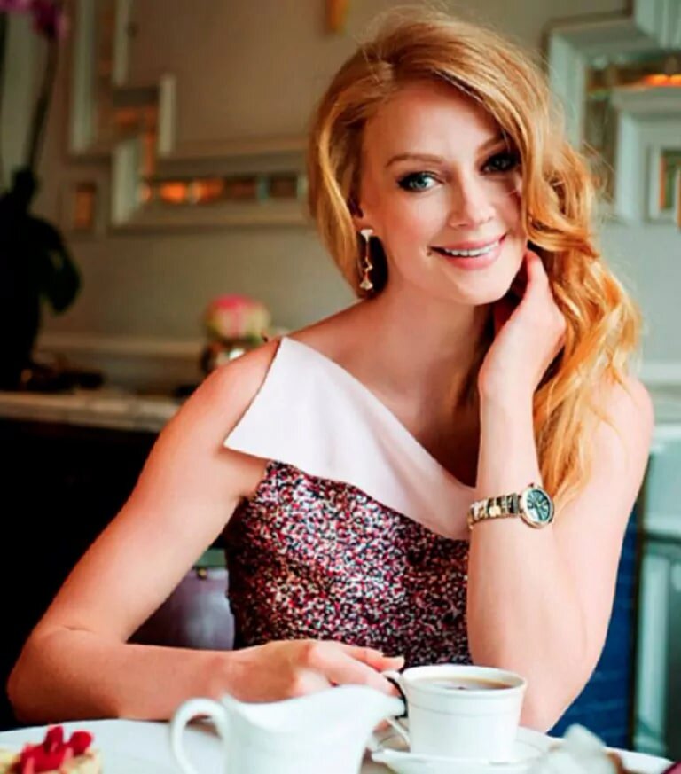 Около окон стоит обеденный стол из массива дерева