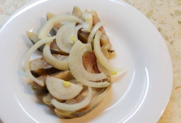 Шаг 1 Филе сельди режем кусками, выкладываем на тарелку. Сверху выкладываем порезанный полукольцами лук. 