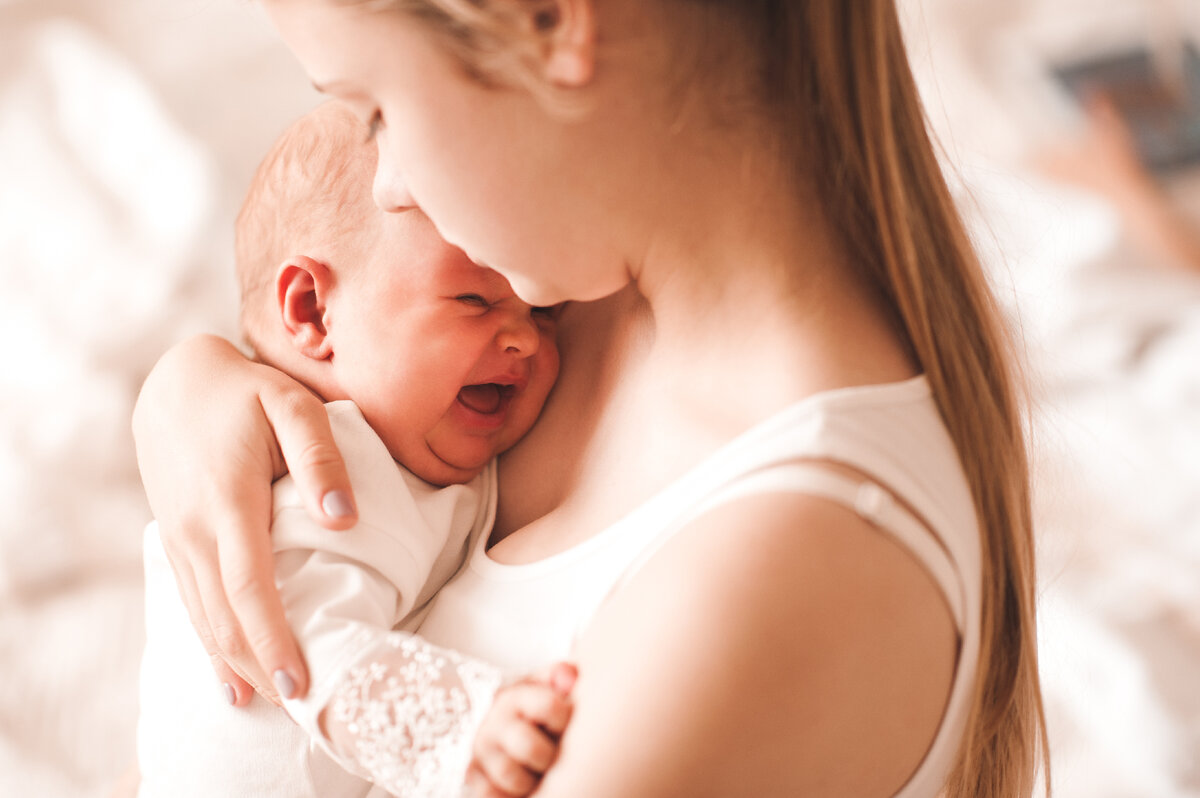 Ребенок плачет на груди. Мать с грудным ребенком. Младенец с коликами у мамы на руках. Мама ребенок Shutterstock. Плачущий младенец с коликами.