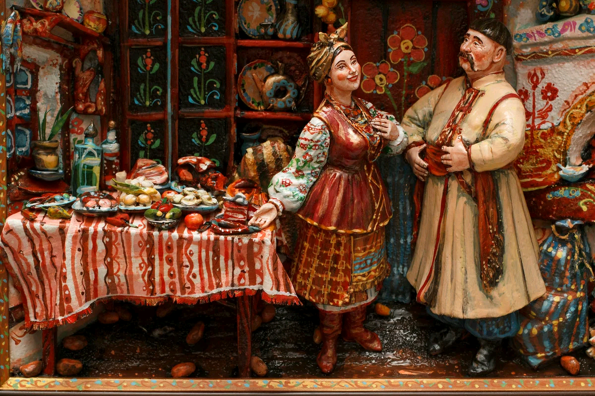 Солоха встречает гостя. На столе в числе угощений и разносолов — жареная колбаска!