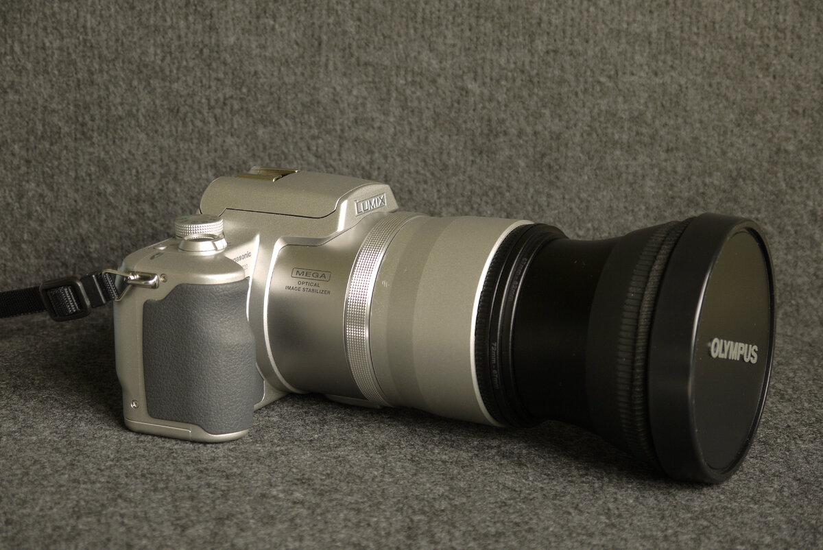 Ещё один мой суперзум Panasonic FZ20 с объективом Olympus TCON-14B, прикреплённым через пару понижающих колец к адаптеру бленды. Обратите внимание на крепление ремня.