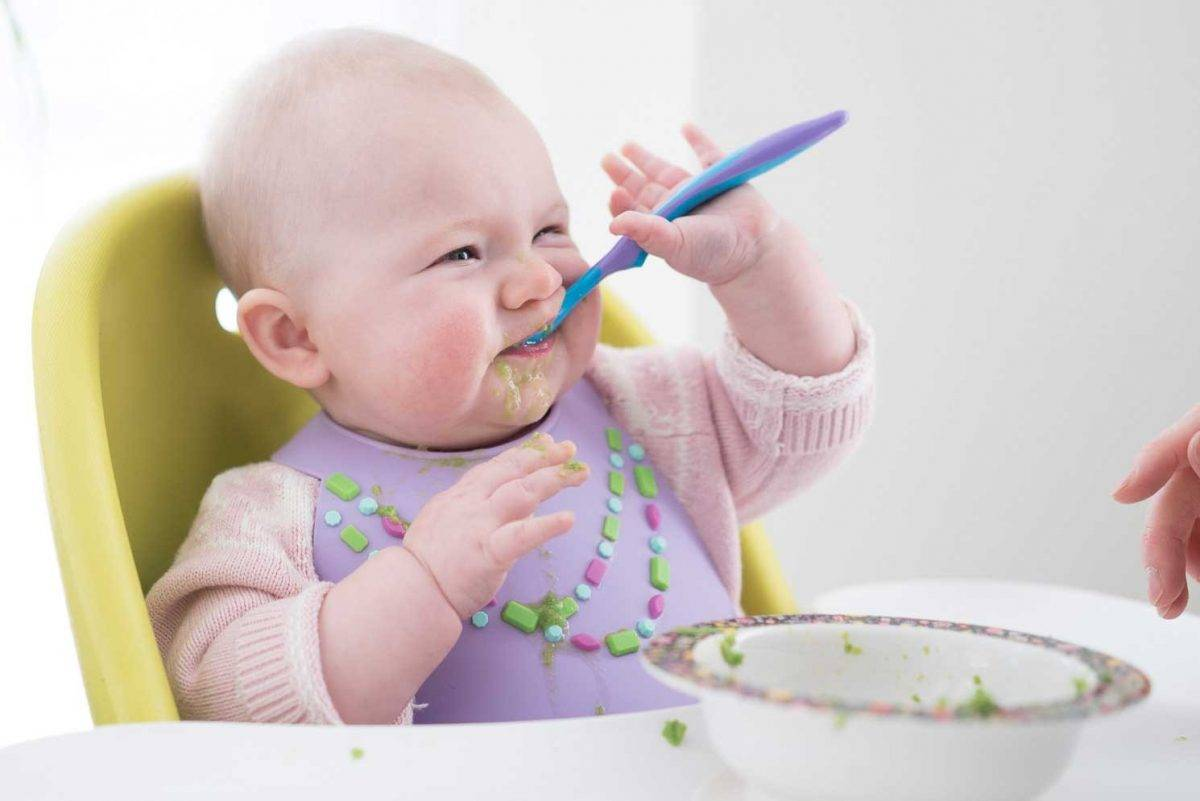 Почему вводить прикорм. Ребенок с ложкой. Ребенок ест прикорм. Малыш ест. Прикорм малыша.