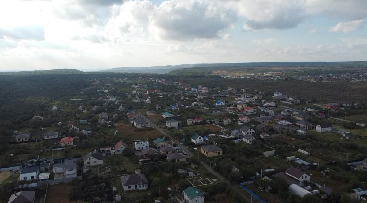 Так выглядит место, где расположен наш участок. Рядом с нами густая стена леса. В нем много родников, образующих небольшие водопады, пешеходные тропы, много грибов и кизила. А если присмотреться, то в лесу виднеется маковка колокольни мужского монастыря. Соседи говорят, что звона почти не слышно, так что мы не стали считать это минусом