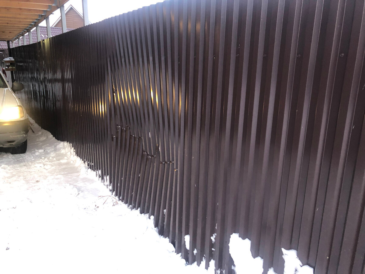 Убрали снежную кучу. Вот так повредился наш забор. 