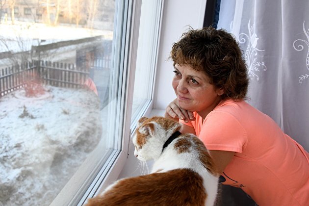 Женщина с кошкой в своей квартире