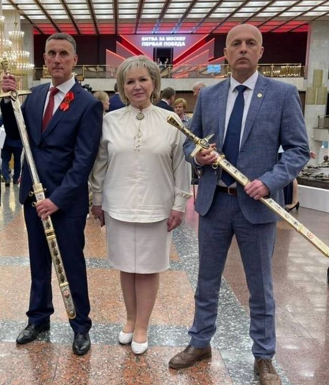 На снимке: слева от сенатора Елены ПИСАРЕВОЙ - Александр  РОЗБАУМ, справа - Владимир ЕРЁМИН с золотыми мечами, полученными ими от  имени Городов воинской славы - Старой Руссы и  Великого Новгорода. Но  сразиться на этих декоративных мечах за пост мэра областного центра - им  не судьба.