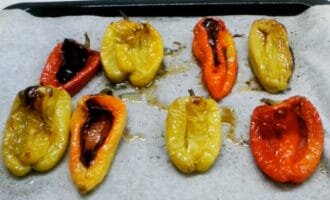 Нагреваем духовку до 200 градусов. Помещаем перцы в духовку и готовим их там около 20-25 минут, переворачивая, если необходимо, до тех пор, пока кожица хорошо не обгорит.