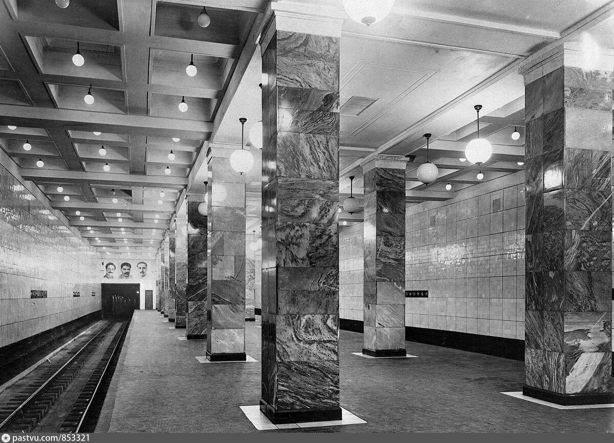 Так выглядела станция "Сокольники" в 1935 году. Портреты партийных деятелей были временным украшением в честь открытия метро. Обратите внимание на освещение: большие люстры-шары и маленькие светильники в каждом углублении (кессоне). С сайта www.pastvu.com.