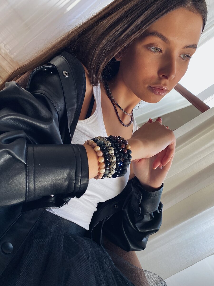 На модели браслеты с лавой, бычьим глазом, синим тигровым глазом, далматиновой яшмой, перламутром и гелиолитом