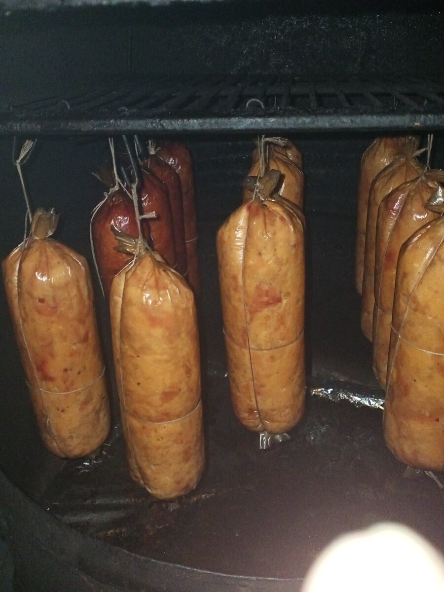 Готовые колбаски в коптильне.