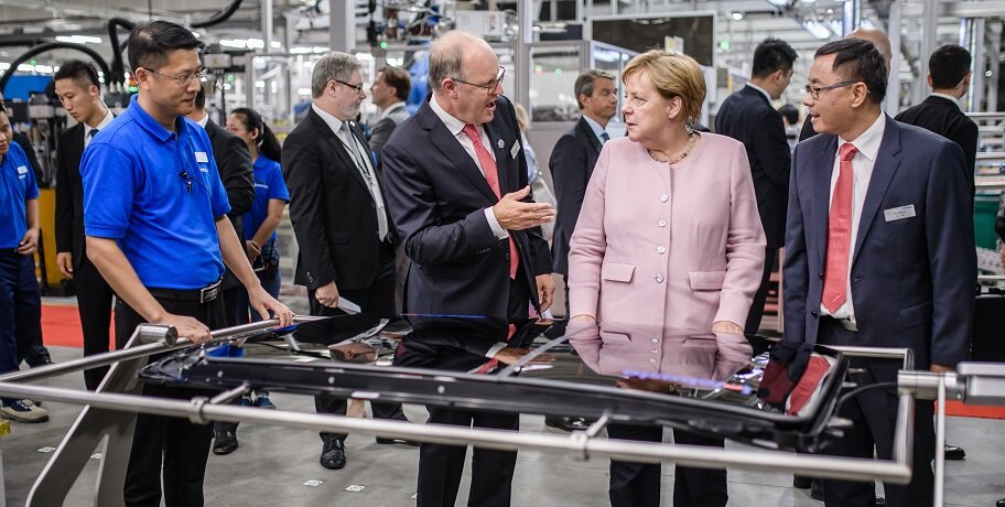 Многие европейские и американские компании разместили свои производства в Китае, среди них и немецкая Webasto. Ангела Меркель во время визита на завод компании в Ухане в 2019 году 
