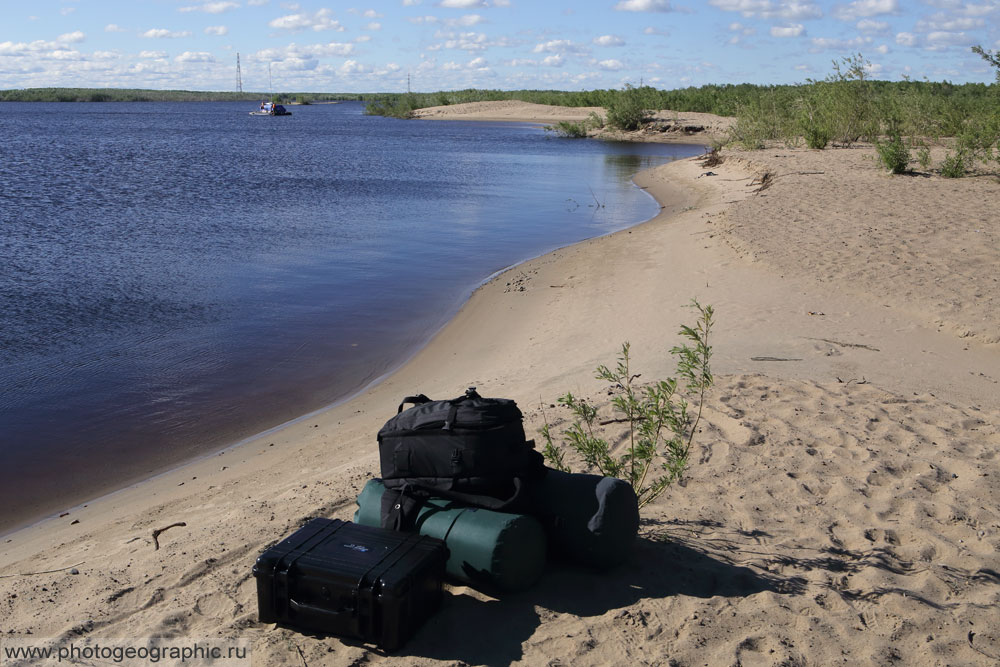 Место встречи на песчаном ленском берегу. За спиной городские многоэтажки, а здесь настоящий речной берег. Груза в этот раз у меня не так много, вот он весь кучкой лежит. Прибыл я слишком рано, поэтому какое-то время пришлось ждать. Но вот уже с другого берега идёт катамаран.