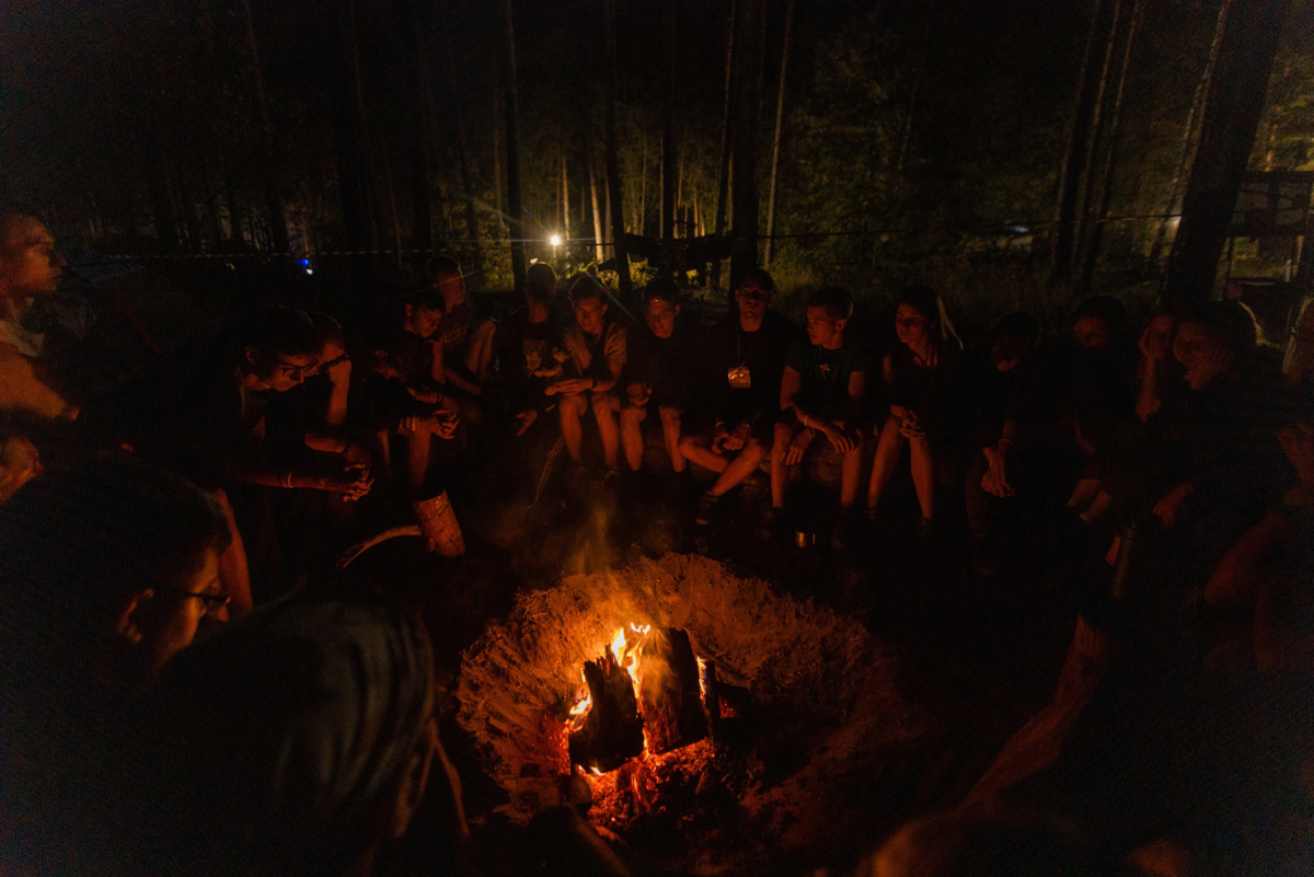 Команда у костра делится впечатлениями о прошедшем дне, о своих эмоциях.