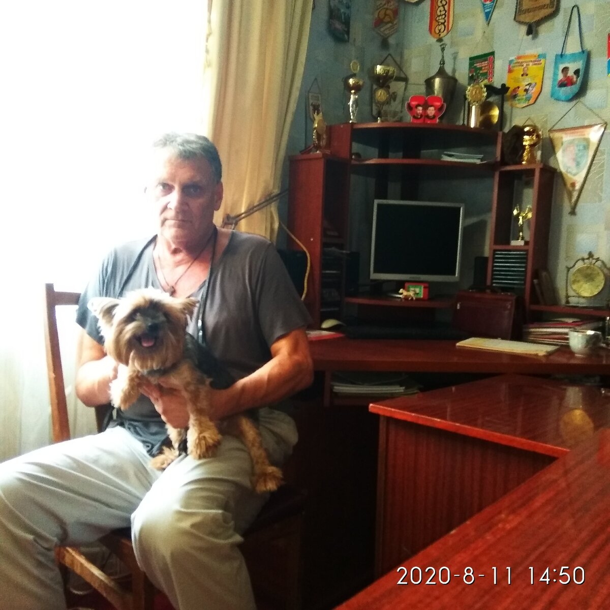    Мне  62 года.     В тренерской . Перед тренировкой.  Моя  помощница Леди.  Кубки и вымпелы  не  мои.  Я  еще  не дорос. 
