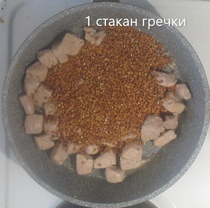 2. К обжаренному мясу добавляем стакан гречки.