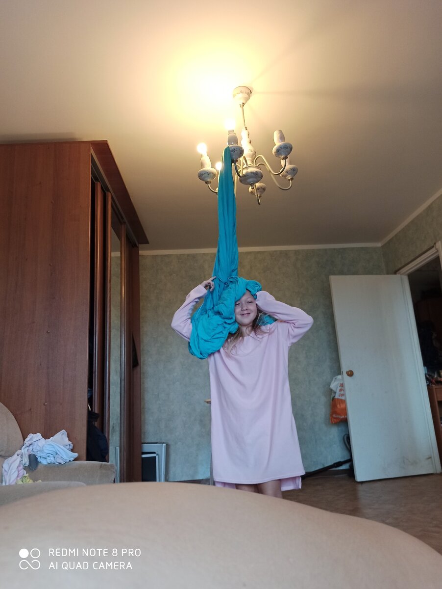 Это я попросила ее повесить белье, а она резко скинула его с головы ) так простыня оказалась на люстре. Зовут девочку Ксюшей. Ей 11 лет. 