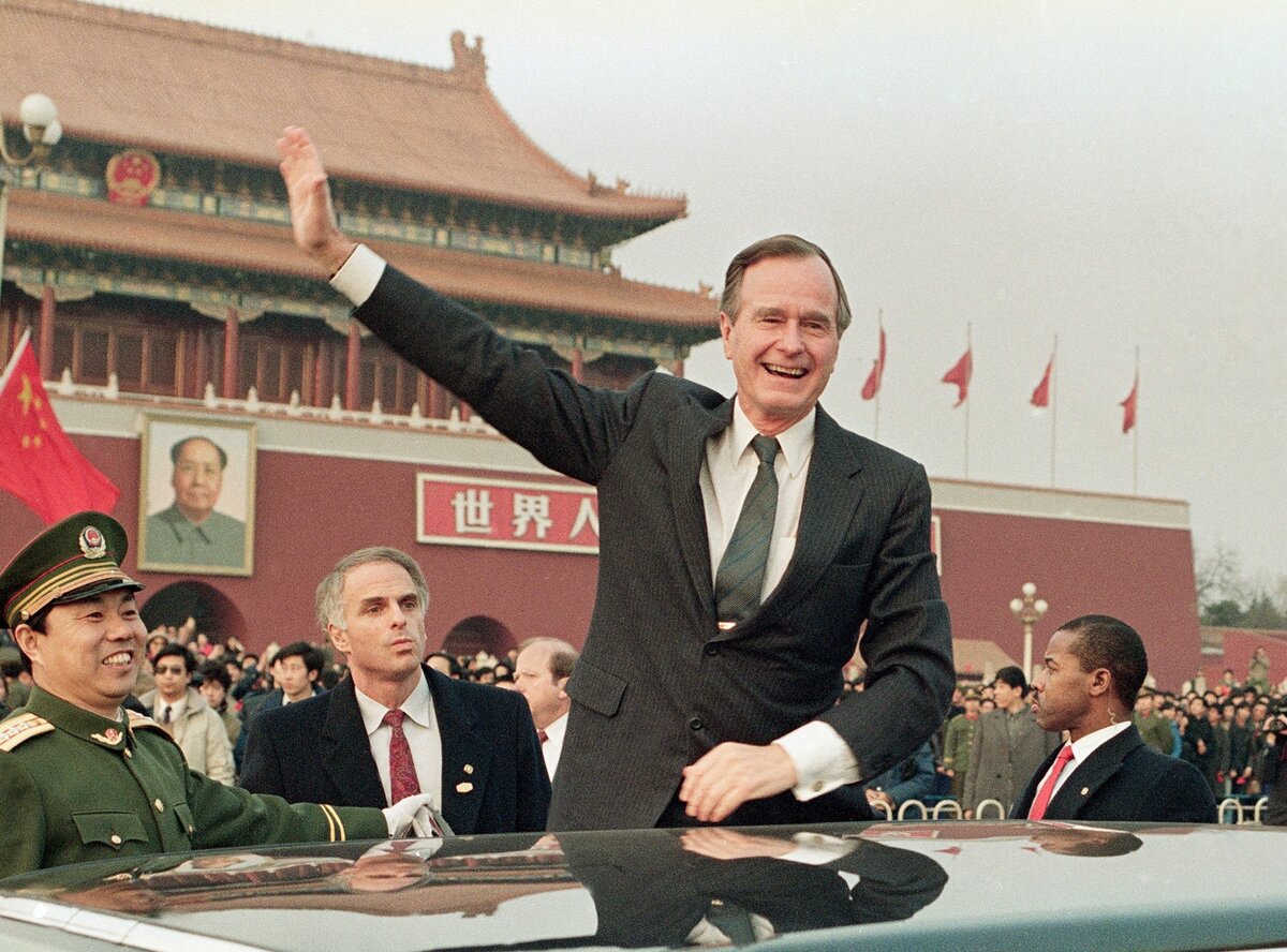 Президент США Джордж Буш машет рукой толпе на площади Тяньаньмань в Пекине, 25 февраля 1989 года.