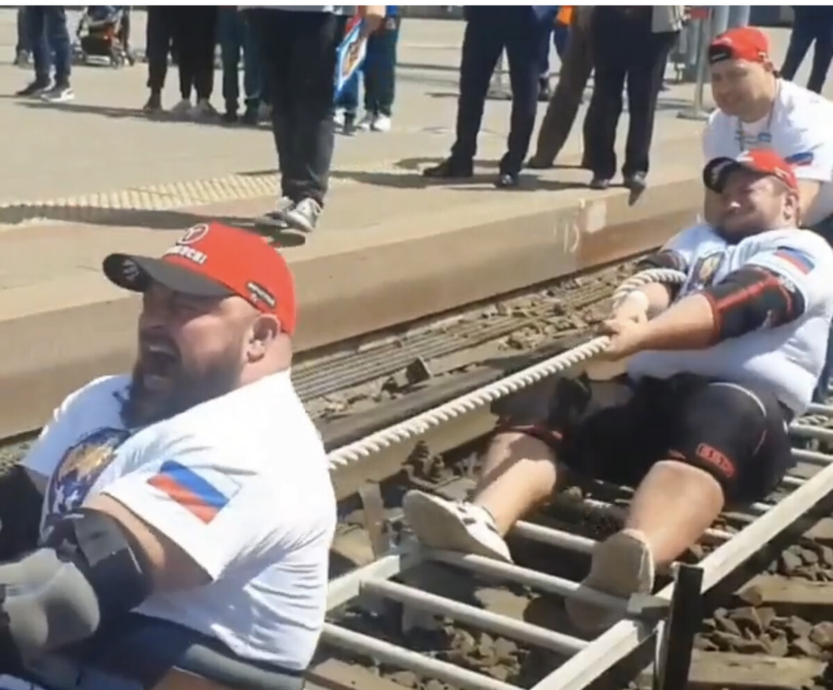 Буксировка поезда руками за канат сидя в исполнении российских атлетов