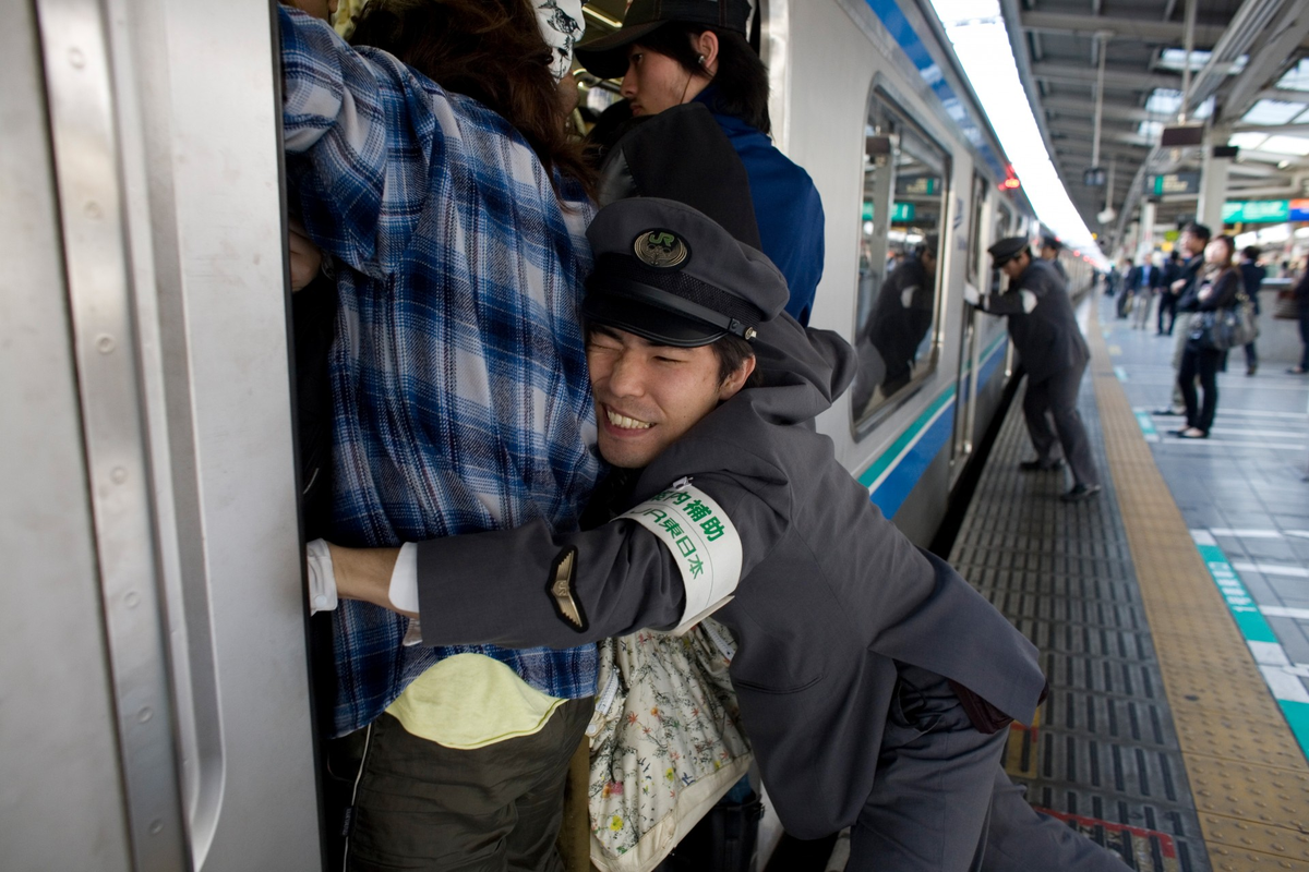 Into the train. Заталкиватель в метро Япония профессия. Метро Токио час пик. Япония Токио метро. Трамбовщик в метро в Японии.