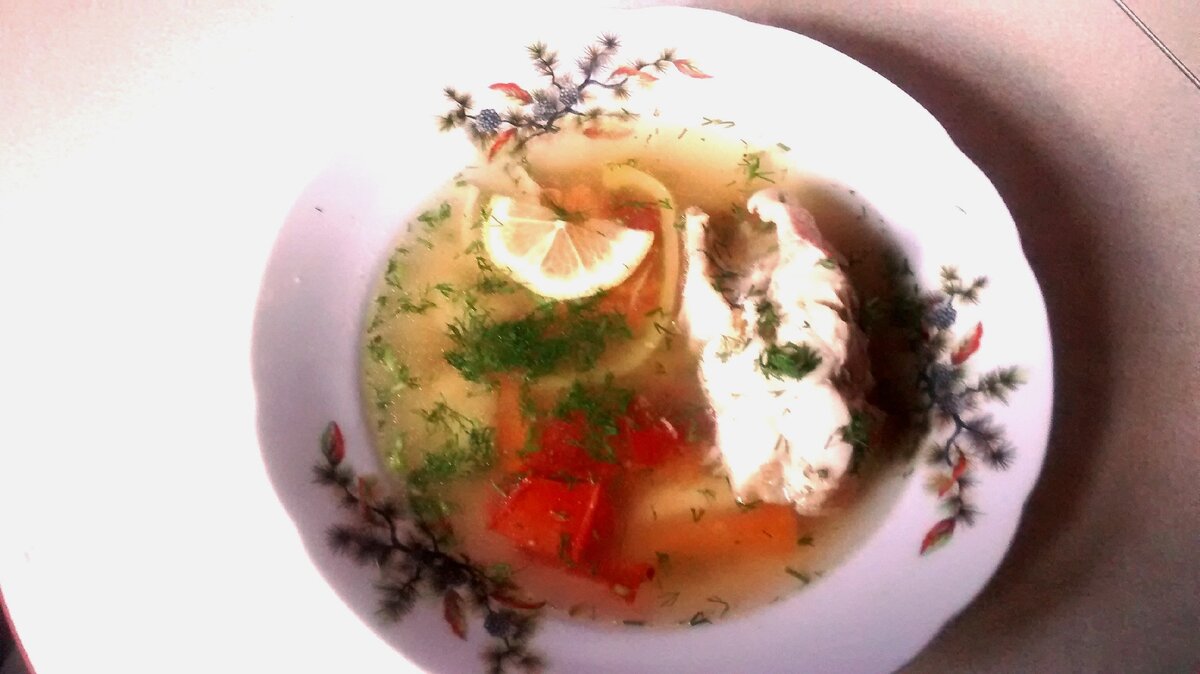 моя уха из морского окуня, приправлена зеленью укропа и лимоном