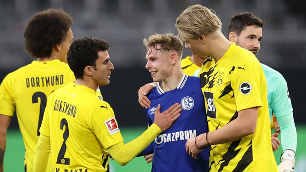 Нападающий Боруссии, Эрлинг Холланд, после игры с Шальке 04, по-дружески беседует с игроком соперников.