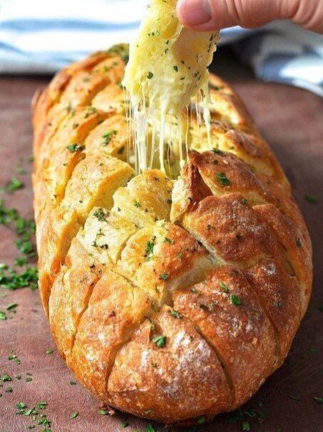 Хрустящий хлебушек пропитанный маслом, сыром и чесночком. 
Ингредиенты:
- 1 французский батон, лучше "вчерашний", можно обычный батон
- 100 г сыра
- 100 г размягченного сливочного масла
- 2-3 зубка чеснока
- зелень петрушки и укропа по вкусу

Сыр потереть на терку, выдавить чеснок, добавить мягкое масло и мелко порезанную зелень, все перемешать.

Духовку нагреть на 200 С. В батоне сделать надрезы наискосок прорезая не до конца, заполнить их хорошо сырной начинкой.

Завернуть батон в фольгу, поставить в духовку на 20 минут. Затем фольгу приоткрыть и оставить еще на 5 минут, чтобы хлеб слегка подрумянился, можно под грилем.

Подавать можно порезав на ломтики по уже надрезанным линиям или порезать рядом острым ножом, тогда начинка останется как бы внутри.

Приятного аппетита!