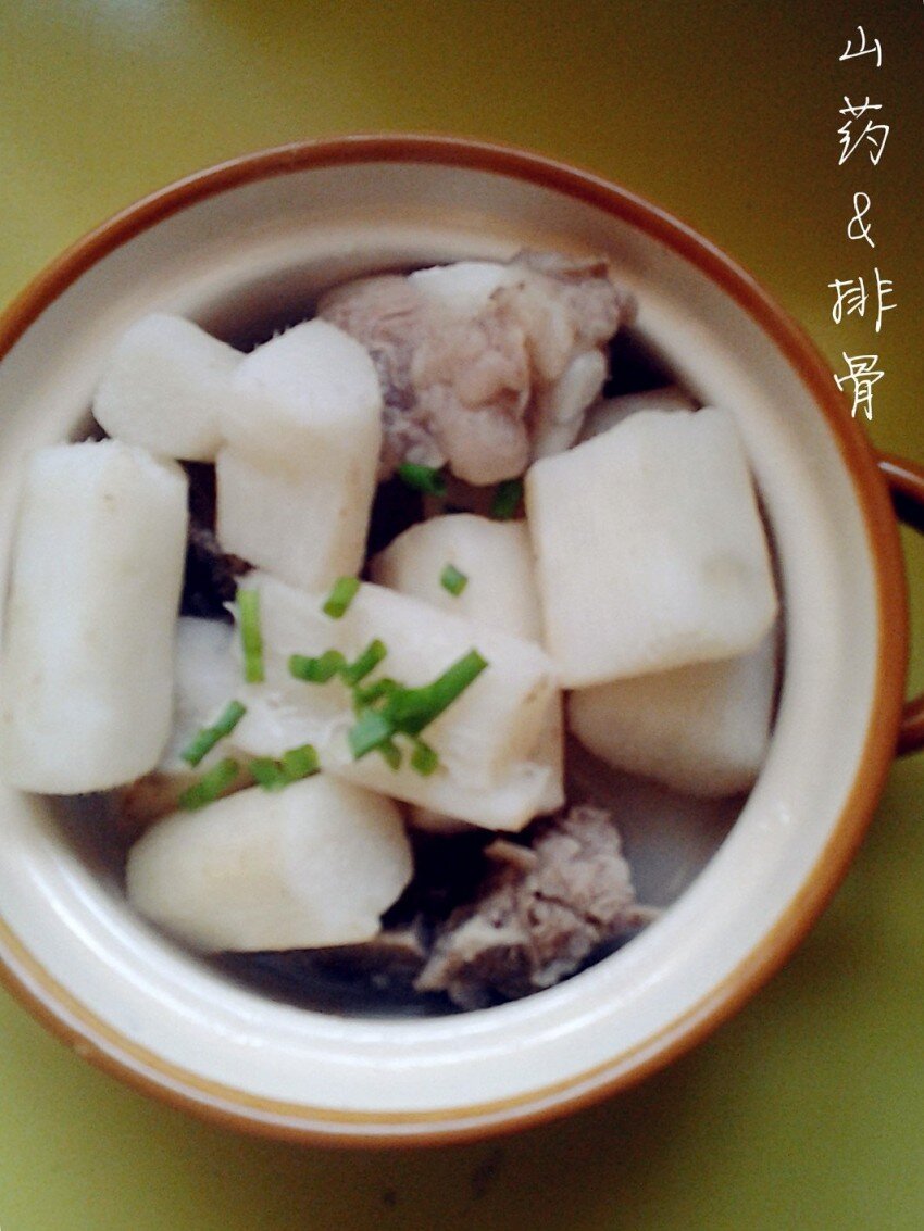 Суп из свиных рёбрышек и китайского ямса, украшенный луком.