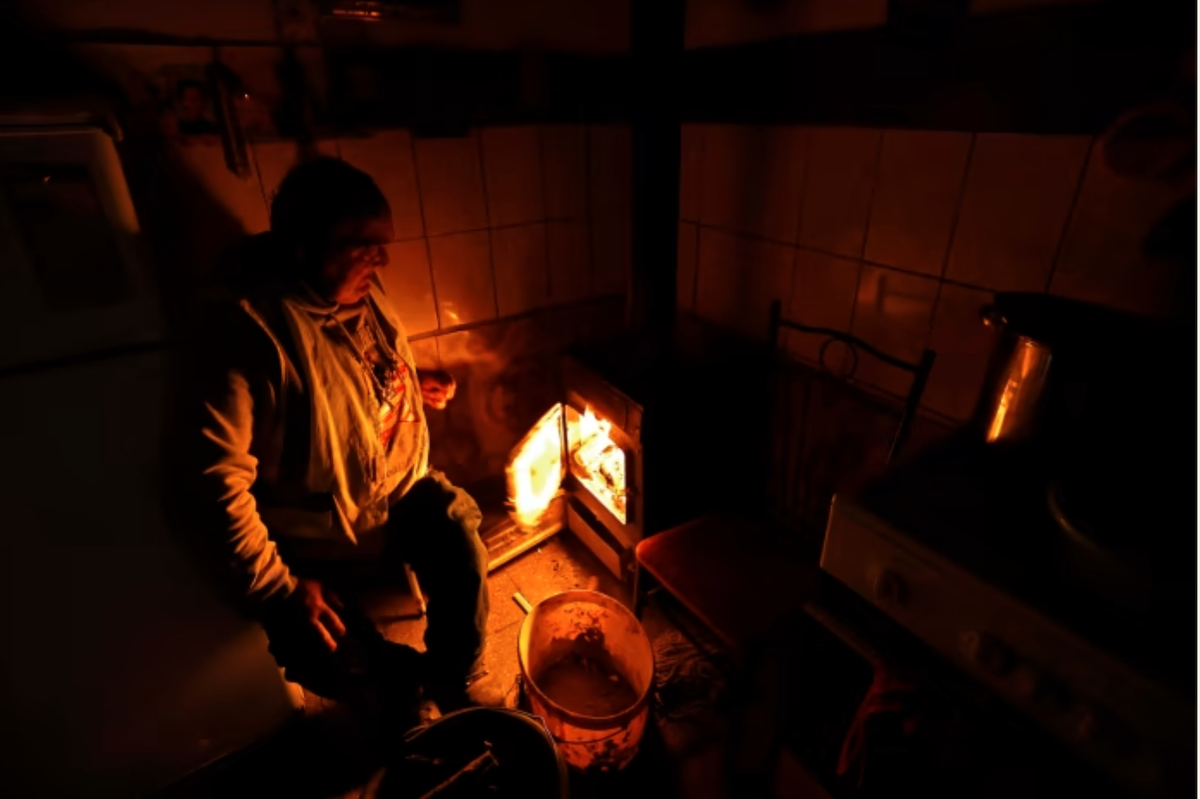 "Золтан Берки подбрасывает дрова в огонь, чтобы обогреть свой дом в Озде, северная Венгрия" (фото из статьи FT)