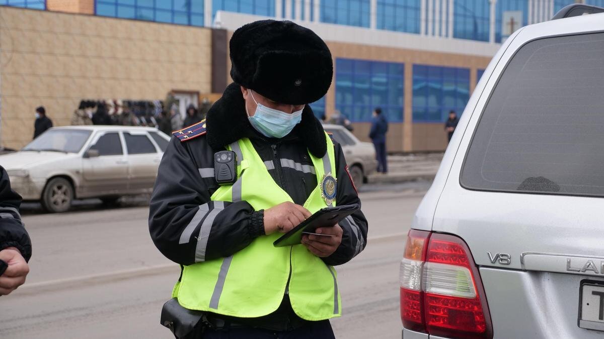    Полицейские проверяет номер авто в планшете:ДП Северо-Казахстанской области